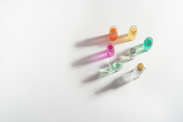 Perfume in a transparent bottle, aromatic oils. Colored shadow on a white background. . Aromatherapy, perfume production. Space for text.