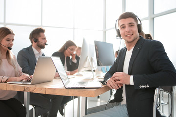 friendly call center operator sitting at his Desk.