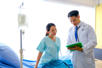 Fototapeta premium Asian male Doctor explaining diagnosis female patient. Doctor discussing test results with patient. The test result was not infected with the corona Viruses, hospital/ coronavirus and -19 concept.