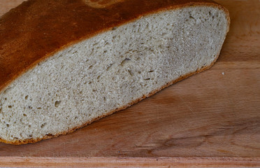 freshly baked bread on a wooden kitchen table, top view.