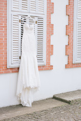 Obraz na płótnie Canvas A white wedding dress hanged on the hanger. Buying a wedding dress.