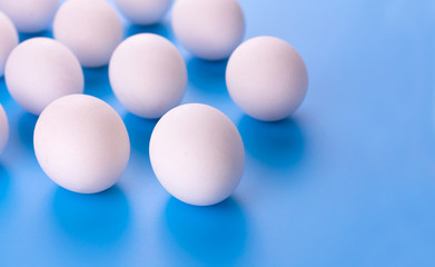  White eggs on a blue background. Copy space.