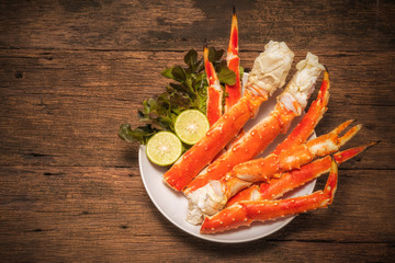 Cooked Organic Alaskan King Crab Legs with lemons,Alaskan King Crab on vintage wooden background.