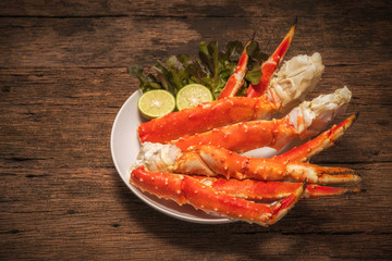Cooked Organic Alaskan King Crab Legs with lemons,Alaskan King Crab on vintage wooden background.