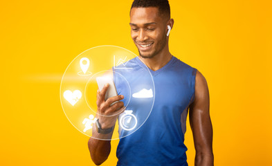 African American guy with earphones using fitness tracker application in mobile device on orange background, collage