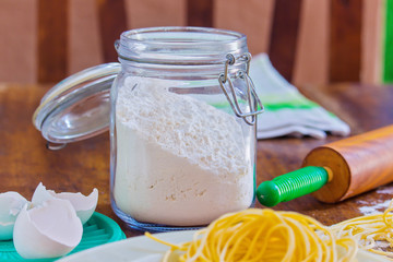 jar of flour and other ingredients to prepare homemade noodles