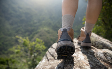 Successful hiker enjoy the view on mountain top cliff edge