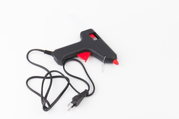 Electric hot glue gun on gray background. Rods for glue gun