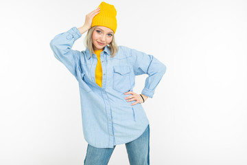 blond girl in a stylish denim shirt and a yellow jacket on a white background
