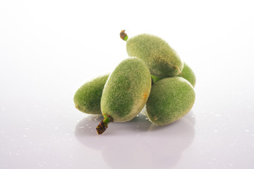 Green almond on white background