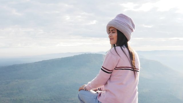 Video clip of Thai female tourists dressed in long-sleeved sweaters and knit hats Smiling happily watching the beauty of the sunrise on the top of the hill Pha Mor E Daeng National Park.