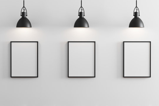 Three black vertical frames mockup with black pendant lights above and white wall, gallery concept, 3d rendering
