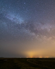 Landscape night shot with the milky way and a dyke and a moor in the forground