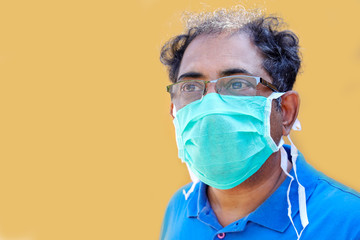 close up south asian man wearing mask for protect virus from air on yellow background,unhealthy and prevention concept