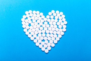 Heart of pills on a blue background.