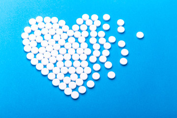 Heart of pills on a blue background.