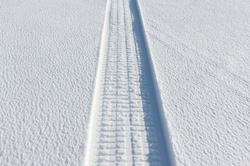 Trail from a snowmobile on a frozen river