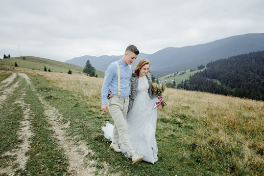 Photoshoot of the bride and groom in the mountains. Boho style wedding photo.