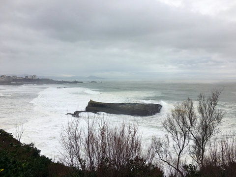 Winter view of ocean with big rock in the water