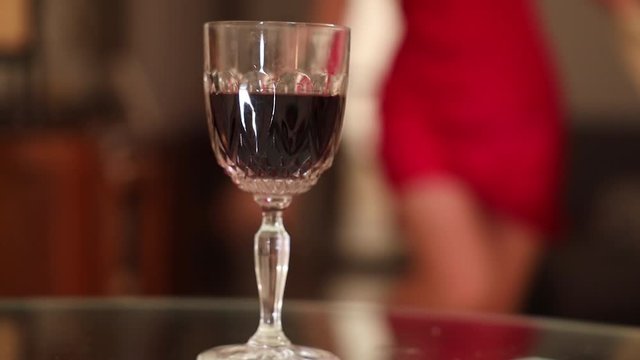 Beautiful sexy woman drinking a red wine at home after event party having fun in red dress