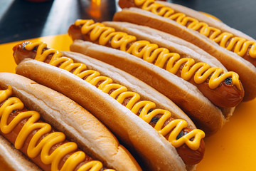 Barbecue Grilled Hot Dogs with  yellow American mustard, On a dark wooden background
