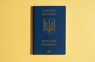 Foreign passport of Ukraine, isolated on the bright yellow sunny background. Trendy travel concept,...