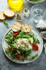 Arugula salad with fresh burrata cheese and tomatoes