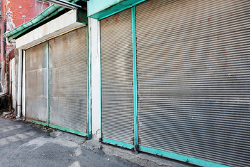 Old vintage shutters of the stores are closed and locked during lockdown