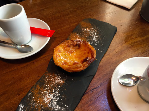 Traditional pasteis de nata on a table with coffees