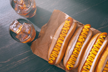 Barbecue Grilled Hot Dogs with  yellow American mustard, On a dark wooden background