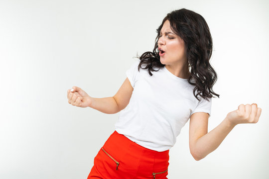 dancing attractive girl in white t-shirt isolated on a white studio background