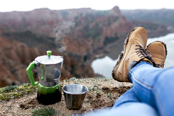 person's boots with mud in a landscape facing the sunrise