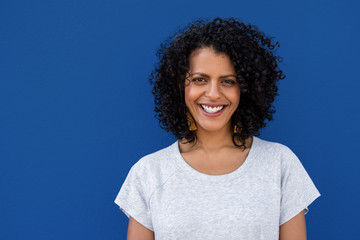 Smiling young woman standing against a colorful blue background