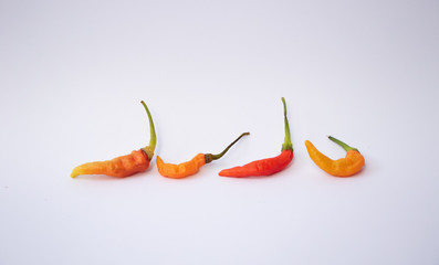four cayenne peppers were isolated against a white background