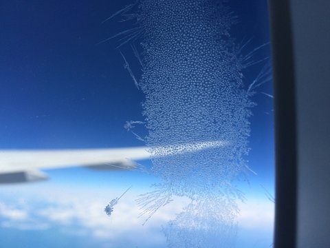 Frost on a plane window during flight