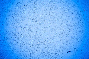 Rain droplets on blue glass background, Water drops on blue glass.