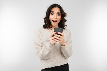 nice girl in a white blouse with a smartphone in hand on a white background with copy space