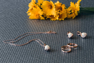 Wedding accessories and jewelry. Wedding rings on a gray background. Engagement. Spring. Flowers