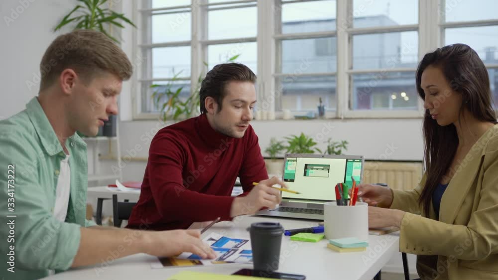 Poster medium shot of designer presenting website interface templates for different devices on laptop scree