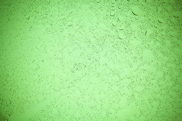 Rain droplets on green glass background, Water drops on green glass.