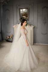 Full-length portrait of a bride in a vintage interior. Lovely young bride is enjoying wedding day, smiling and looking forward. Beautiful bride portrait.