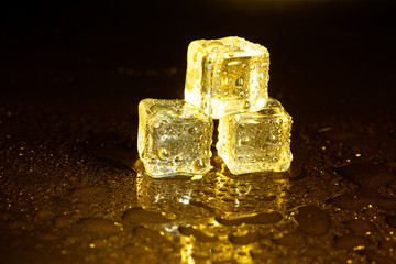 ice cubes on a reflections yellow light.