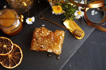 Honeycomb with delicious honey on black background 