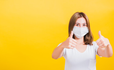 woman wearing mask protection, show thumb finger good stopping virus outbreak control