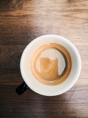 White cup of hot coffee on table