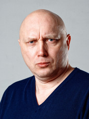 Obraz premium Portrait of a bald cheerful man on a gray background