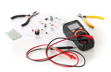 Different electronic parts or components, measurement tool and pliers on white with pcb wiring...