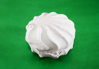 white marshmallow on a green background. Close-up.