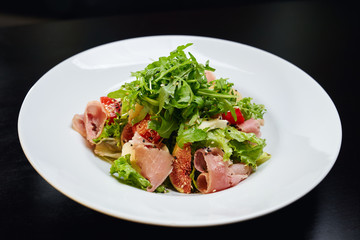 Salad with ham, figs and vegetables.