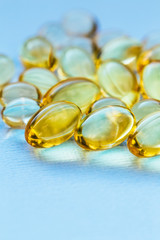 Cod liver oil capsules in a fish shape with copy space. Healthcare concept